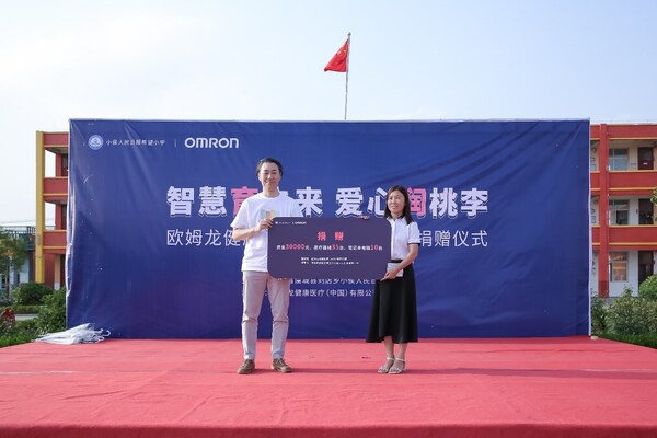 歐姆龍常務(wù)副總經(jīng)理東谷隆史與小侯人民日?qǐng)?bào)希望小學(xué)校長(zhǎng)趙冬梅在捐贈(zèng)儀式合影